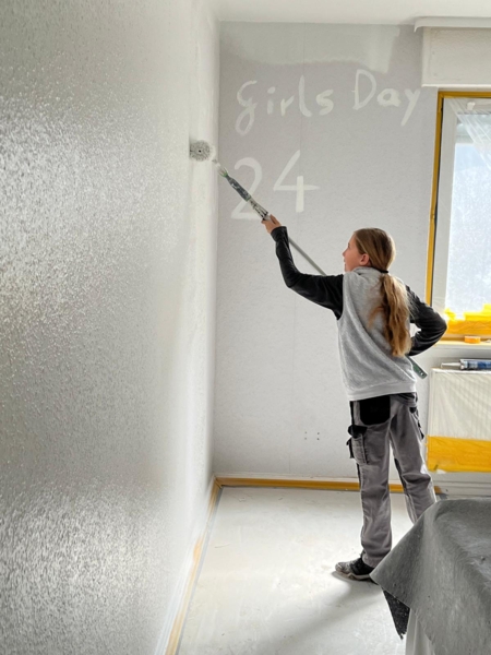 Girls'Day-Teilnehmerin malt Girls'Day an die Wand